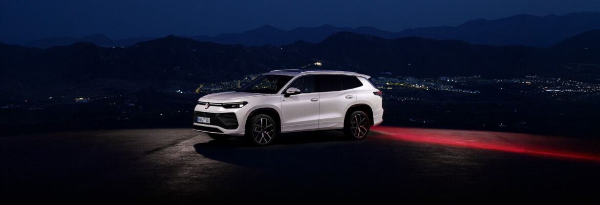 Volkswagen Tayron at night with the city behind