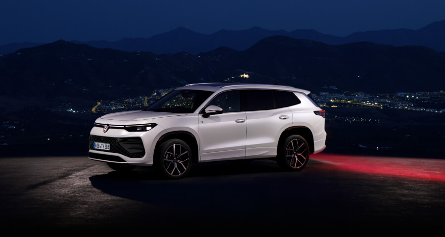 Volkswagen Tayron at night with the city behind